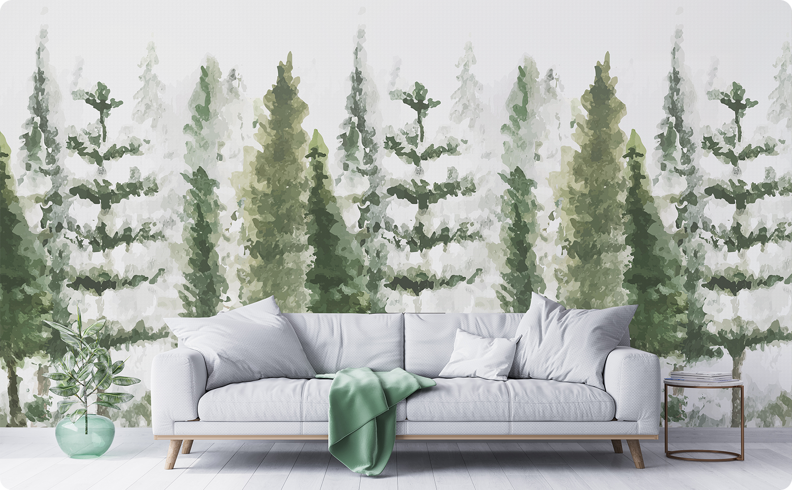 Watercolor pine tree wallpaper mural in soft green and gray behind a light gray sofa